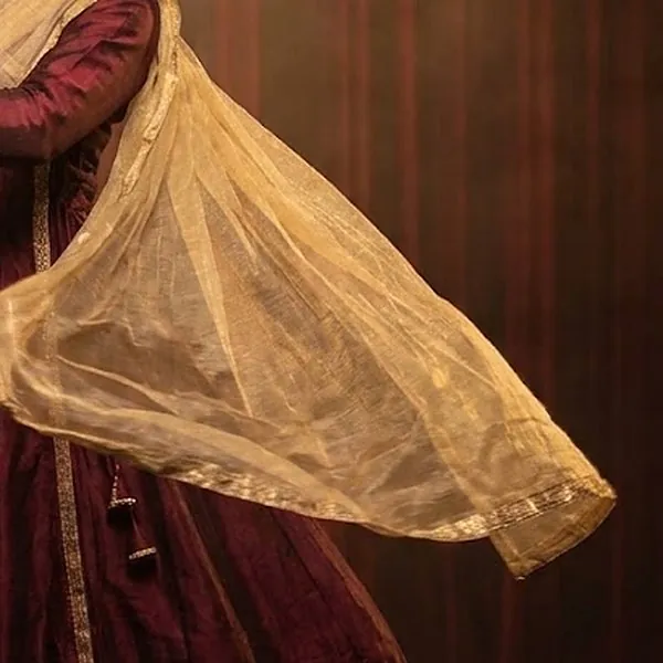Gold dupatta sweeping through the air during a turn