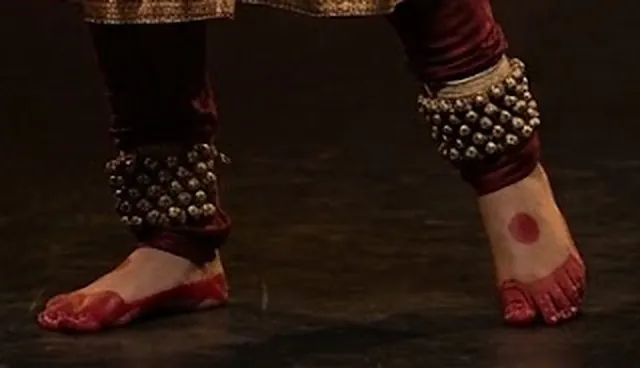 Brass ghungroo bells on both ankles, feet painted with alta