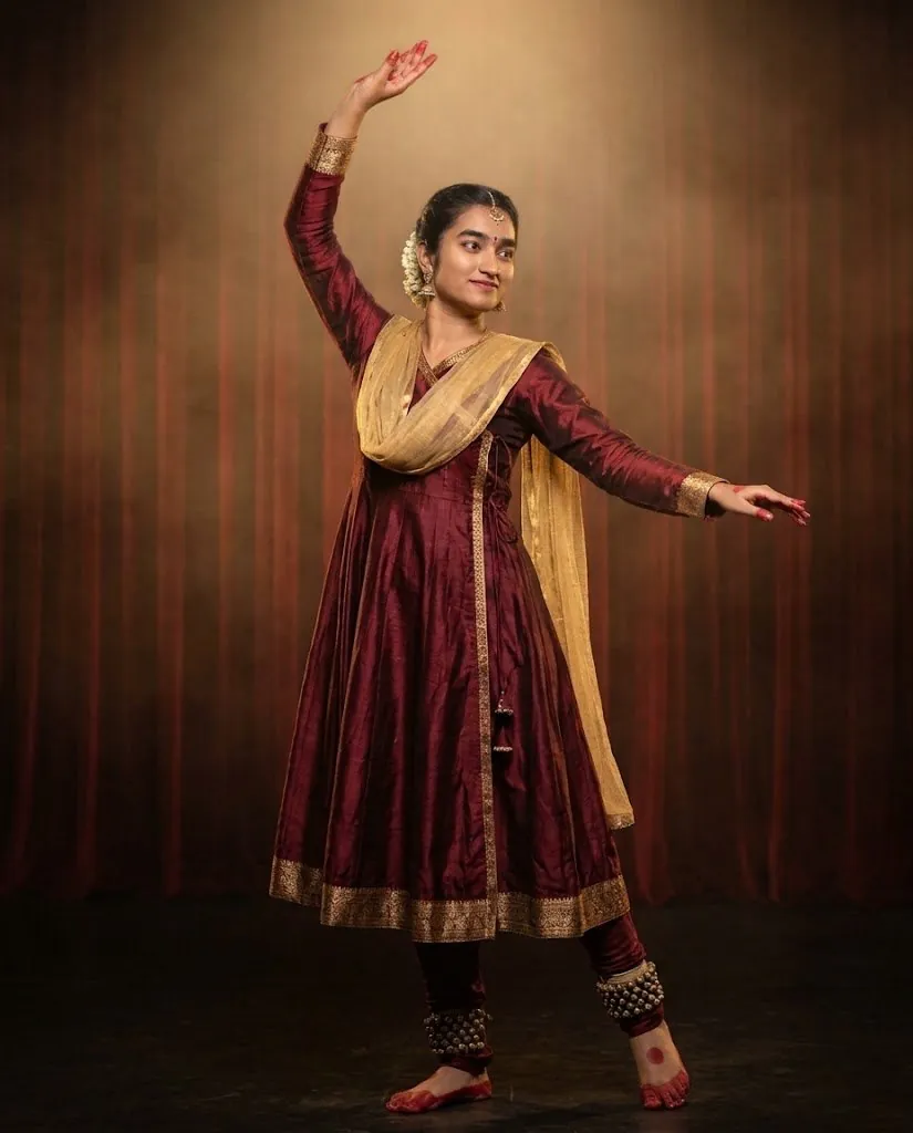 Ashmitha Gad in a Kathak pose, right arm raised, left arm extended